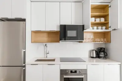 a white kitchen with a sink and a microwave at Blueground Williamsburg view nr East River NYC-1958 in Brooklyn