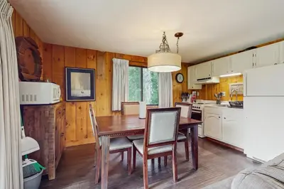 a kitchen with a wooden table and a dining room at Ski Haus Retreat in West Dover