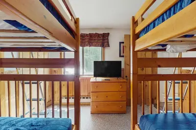 a bedroom with two bunk beds and a tv at Ski Haus Retreat in West Dover