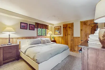 a bedroom with a bed and a desk with a lamp at Ski Haus Retreat - Unit A in Dover