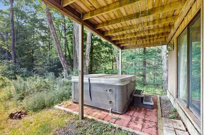 an outdoor hot tub on a porch of a house at Ski Haus Retreat - Unit A in Dover