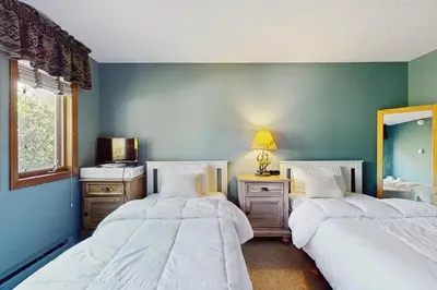 two beds in a room with blue walls at Snow Mountain Village 36D in Dover