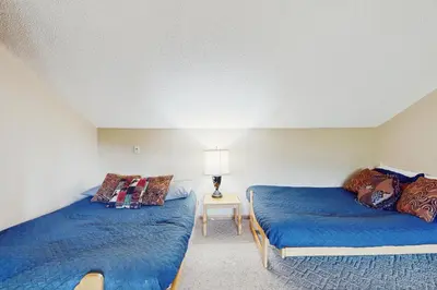 a bedroom with two beds and a table with a lamp at Snow Mountain Village 36D in Dover