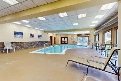 a pool in a large room with tables and chairs at Snow Mountain Village 36D in Dover
