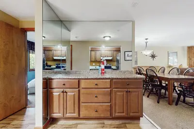 two views of a kitchen and a dining room with a table at Snow Mountain Village 36D in Dover