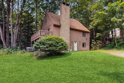 a house with a chimney on the side of it at Ski Haus Retreat - Unit B in Dover