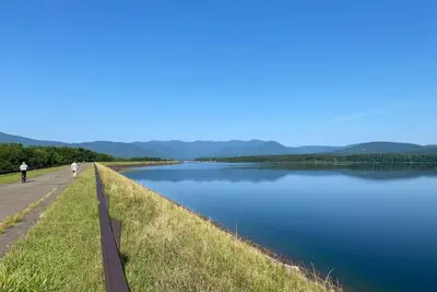 two people walking on a path next to a lake at Ashokan Reservoir Treetop Suite in the Catskills in Olivebridge