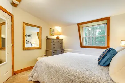 a bedroom with a bed and a dresser and a mirror at Ashokan Reservoir Treetop Suite in the Catskills in Olivebridge
