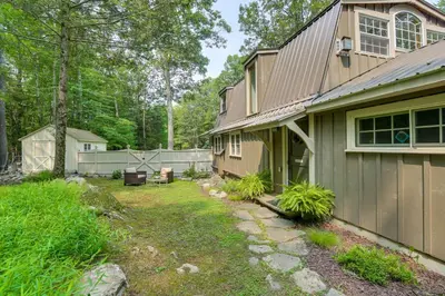 a yard next to a house with a fence at Ashokan Reservoir Treetop Suite in the Catskills in Olivebridge