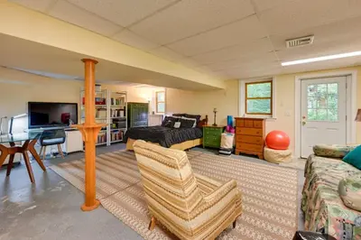 a living room with a bed a couch and a table at Tolland Lake Escape Kayaks Deck and Nature Trails in Sandisfield