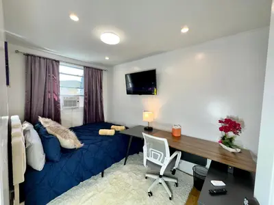 a bedroom with a blue bed and a desk at BP STAYS - Hotel-Style, No Host, Professionally Managed ID260 in Jersey City