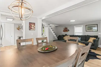 a dining room and living room with a table and chairs at Lake Me Home in East Hampton