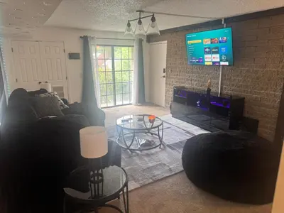 a living room with a couch and a tv at Elegance Escape
