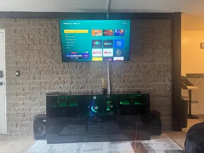 a flat screen tv hanging on a brick wall at Elegance Escape