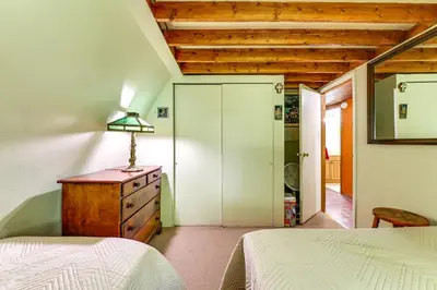 a bedroom with a bed and a dresser with a lamp on it at Hike and Fish Delaware River Cabin with Views in East Branch