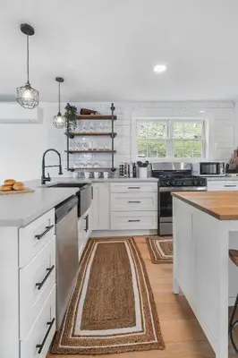 a kitchen with white cabinets and stainless steel appliances at Hudson Escape W Hot Tub Bridge View in Highland