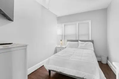 a white bedroom with a bed and a window at Sunny Room Steps from SCSU in New Haven