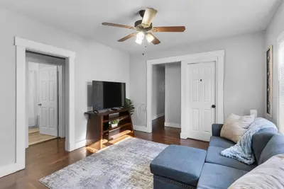 a living room with a couch and a ceiling fan at Sunny Room Steps from SCSU in New Haven