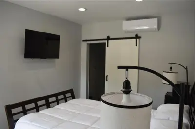 a bedroom with a bed with a lamp on it at Tannersville Village Rooms on Saw Mill Creek in Tannersville