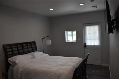 a bedroom with a bed and a window and a door at Tannersville Village Rooms on Saw Mill Creek in Tannersville