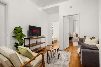 a living room with a couch and a tv at Chic East Village Retreat Comfort in Heart of NYC in New York