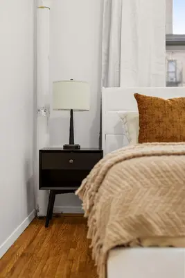 a bedroom with a bed and a lamp on a nightstand at Chic East Village Retreat Comfort in Heart of NYC in New York