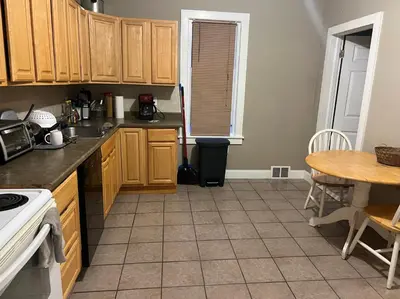 a kitchen with wooden cabinets and a table at Near East Stroudsburg University in East Stroudsburg