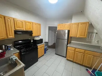 a kitchen with wooden cabinets and a stainless steel refrigerator at The Peppermint in Mount Vernon