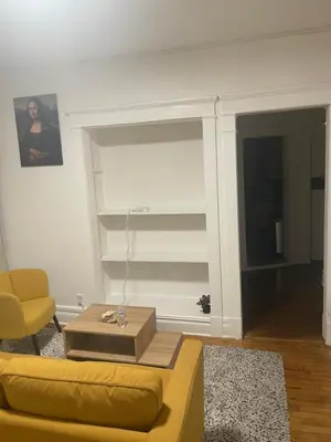 a living room with a yellow couch and a table at The Peppermint in Mount Vernon