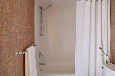 a bathroom with a shower with a white shower curtain at The Kent Collection - The Garden Cottages in Kent