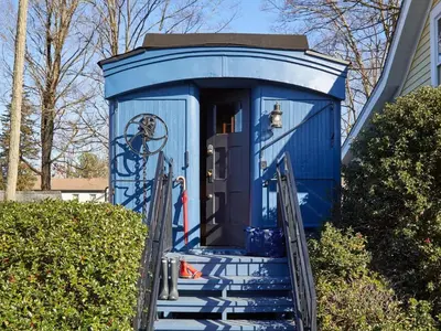 a blue out house with stairs leading to the door at The Kent Collection - The Garden Cottages in Kent