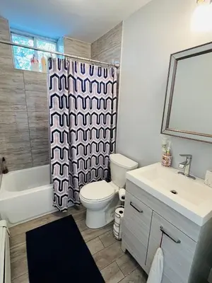 a bathroom with a toilet and a sink and a shower curtain at Renovated private urban flat - 20 min to Manhattan NYC in Jersey City