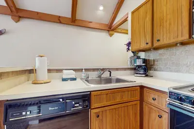 a kitchen with wooden cabinets and a sink at 17A Mountain Village #241 in Dover