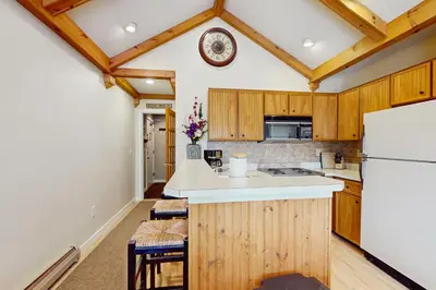 a kitchen with wooden cabinets and a white refrigerator at 17A Mountain Village #241 in Dover