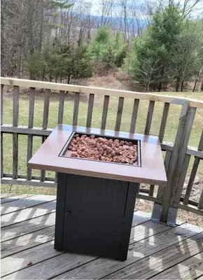 a wooden table with a fire pit on a deck at Cute Cozy Cottage Glenford New York in Glenford