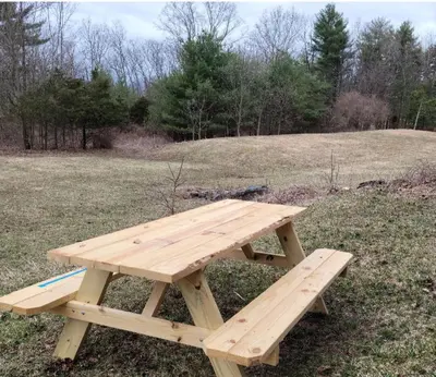 a wooden picnic table sitting in the middle of a field at Cute Cozy Cottage Glenford New York in Glenford