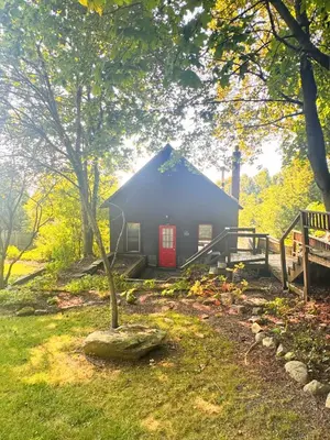 a small house with a red door in a yard at Cute Cozy Cottage Glenford New York in Glenford