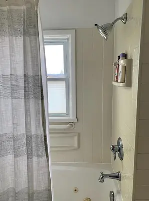 a bathroom with a shower and a bath tub with a window at Cute Cozy Cottage Glenford New York in Glenford