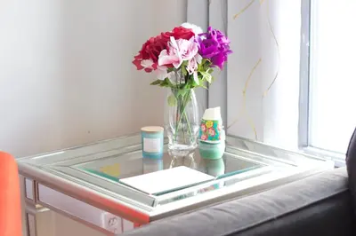 a glass table with a vase of flowers on it at Stay In Times Square! 2-Bedroom Apartments in New York