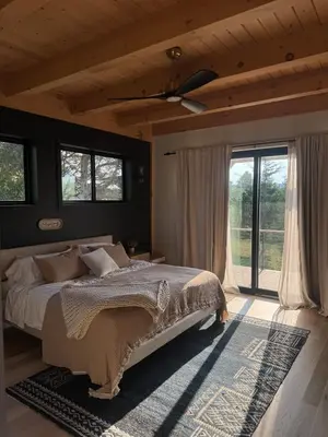a bedroom with a bed and a large window at Gray Owl Lodge- A Serene Lakefront Retreat on Sleepy Hollow Lake near Hudson NY in Athens