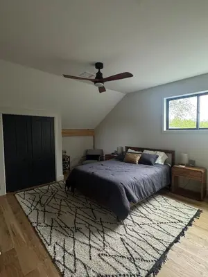 a bedroom with a bed and a ceiling fan at Gray Owl Lodge- A Serene Lakefront Retreat on Sleepy Hollow Lake near Hudson NY in Athens