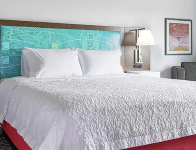 a bedroom with a white bed with a blue headboard at Hampton Inn & Suites By Hilton North Haven in North Haven