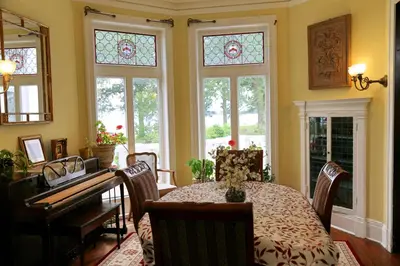 a dining room with a table and a piano at Waterfront Retreat Center in New Rochelle
