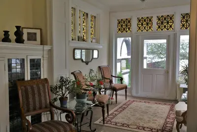 a living room with a table and chairs and windows at Waterfront Retreat Center in New Rochelle