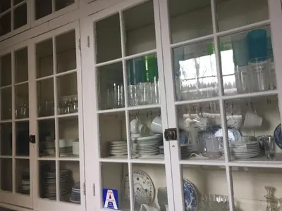 a cabinet filled with plates and dishes at Waterfront Retreat Center in New Rochelle