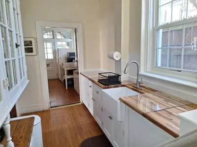 a kitchen with white cabinets and a sink and a window at Waterfront Retreat Center in New Rochelle