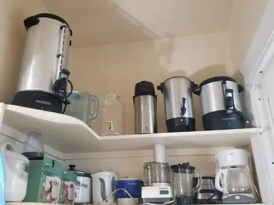 a cupboard filled with pots and pans at Waterfront Retreat Center in New Rochelle