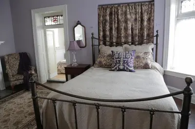 a bedroom with a canopy bed with pillows and a mirror at Waterfront Retreat Center in New Rochelle