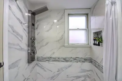 a bathroom with a marble shower with a window at Luxurious 3 Bedroom, 3 Bathroom, Entire Home in Catskill in Catskill