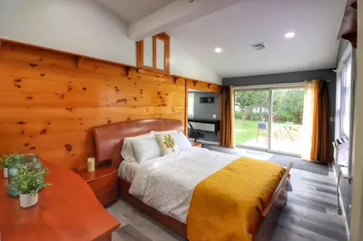 a bedroom with a bed and a wooden wall at Luxurious 3 Bedroom, 3 Bathroom, Entire Home in Catskill in Catskill